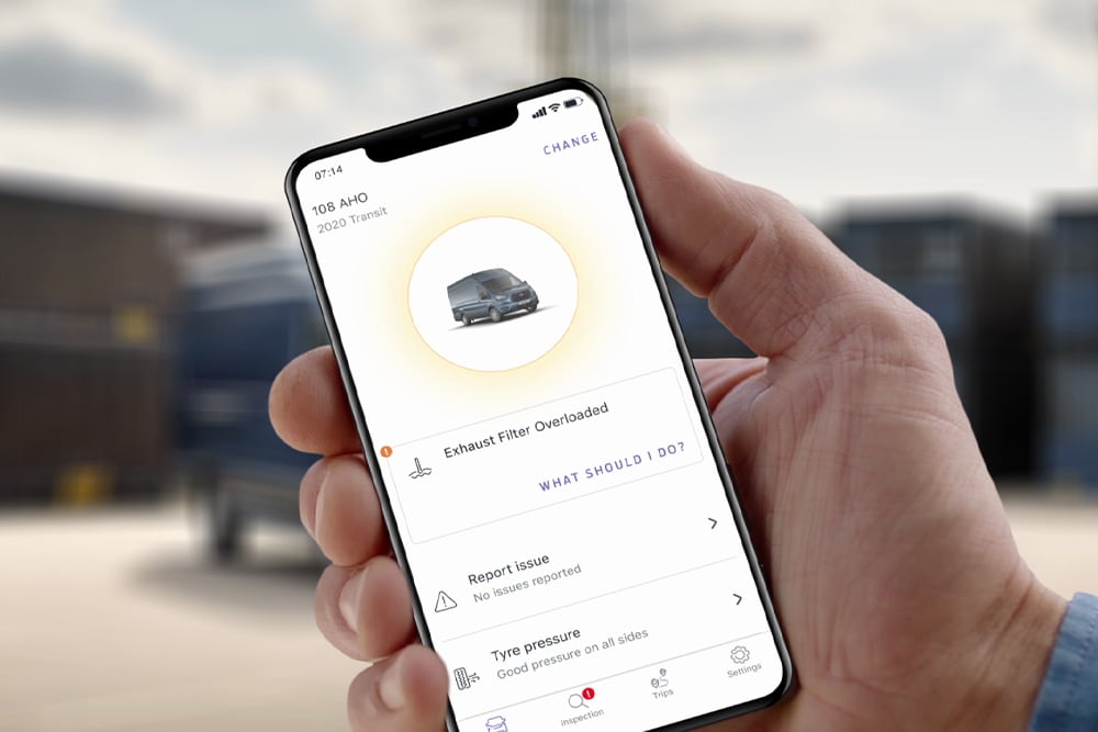 Eine Hand hält ein mobiles Gerät, das die Ford Telematics Drive App zeigt.