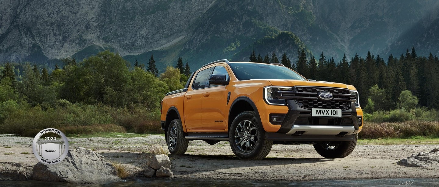 Ford Ranger in Orange. Dreiviertelansicht, parkt vor Berglandschaft