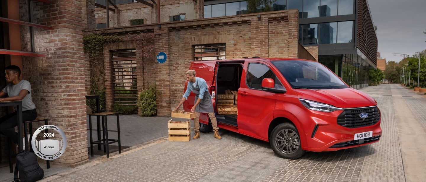 Ford Transit Custom in Rot. Dreiviertelansicht mit Mann der Ware ausladet.