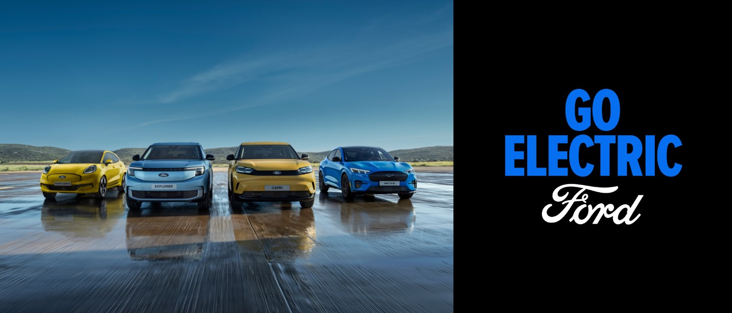Puma Gen-E, Explorer, Capri und Mustang Mach-E stehen auf einer nassen Fahrbahn. Frontansicht der Fahrzeuge. 