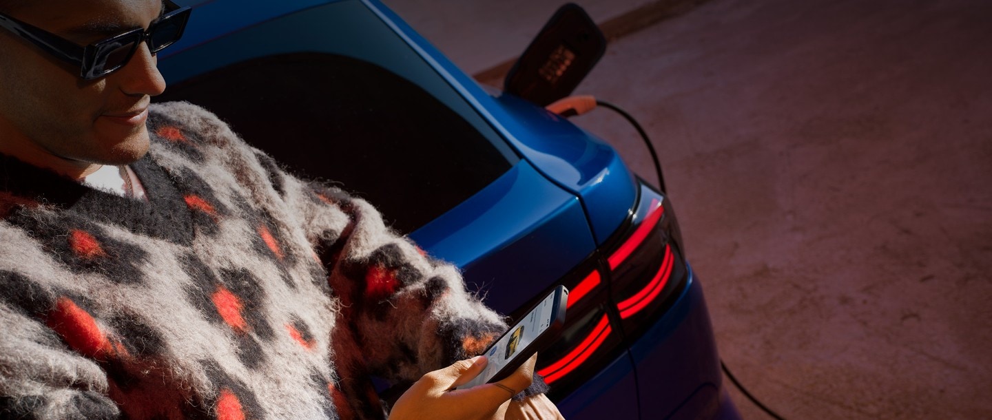Mann sieht auf sein Smartphone mit geöffneter FordPass App.