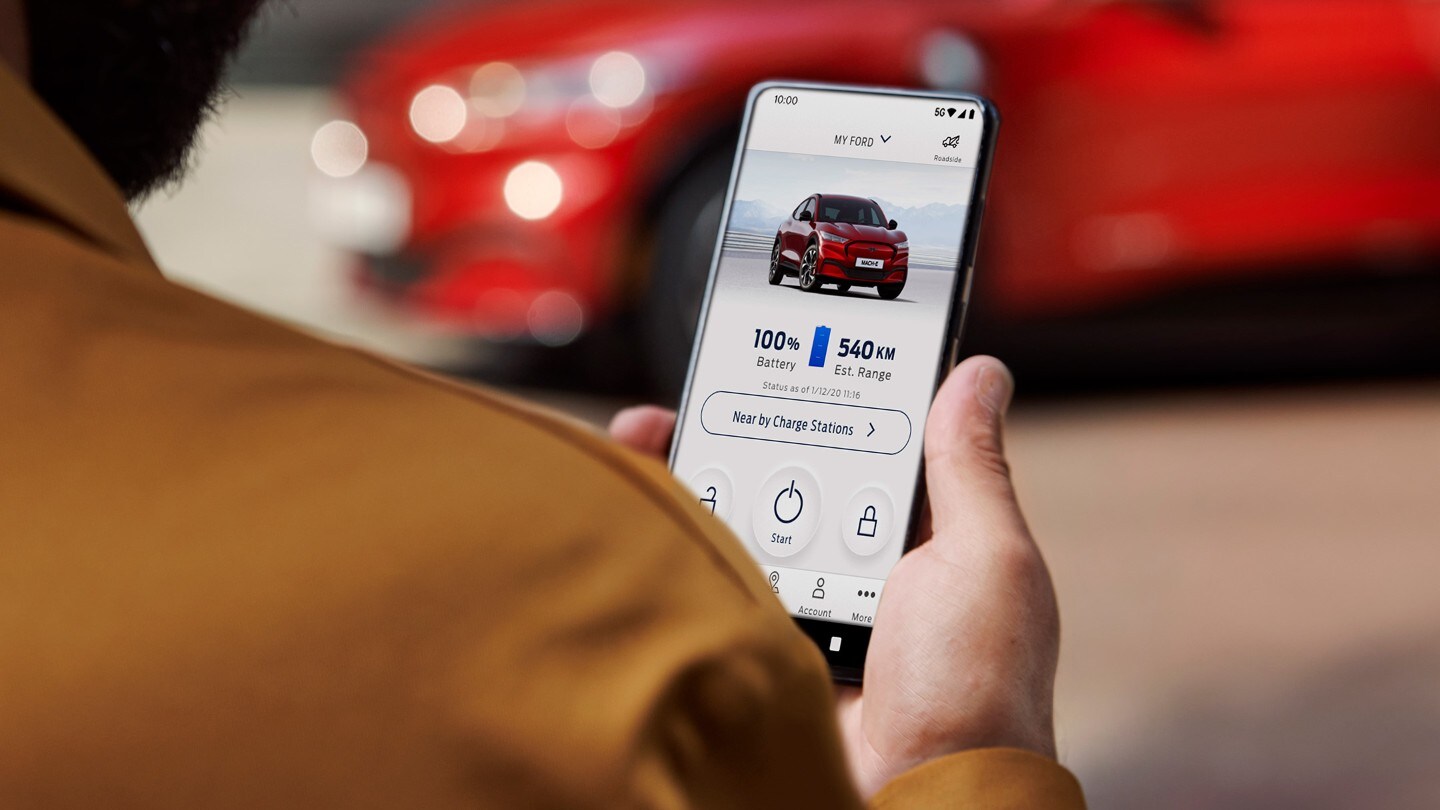 Mann prüft den Ladestand seines Ford Mustang Mach-E über die FordPass App.