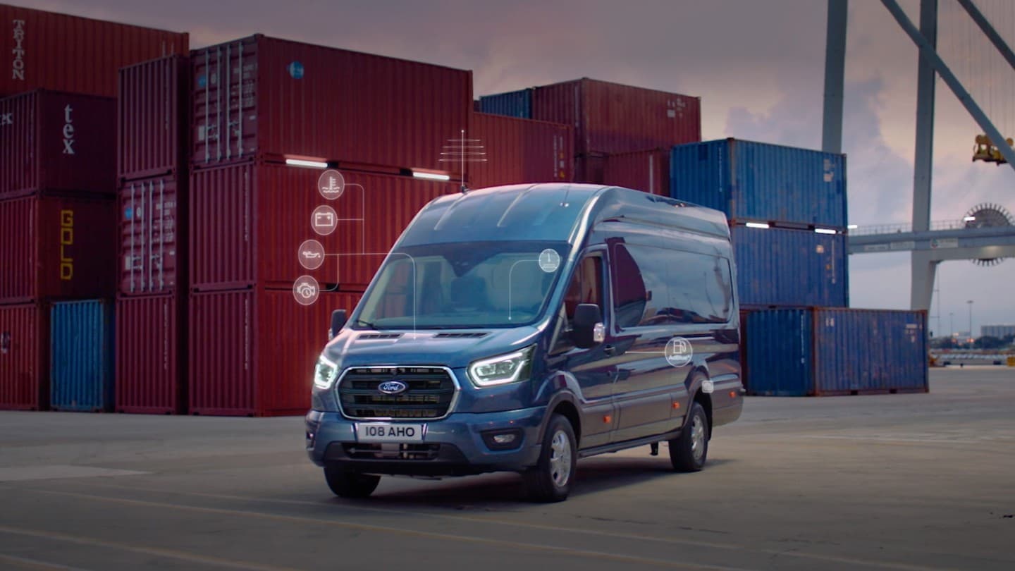 Ford Pro™ Telematics – Ford Transit Kastenwagen in Blau. Dreiviertelansicht, vor Containern parkend