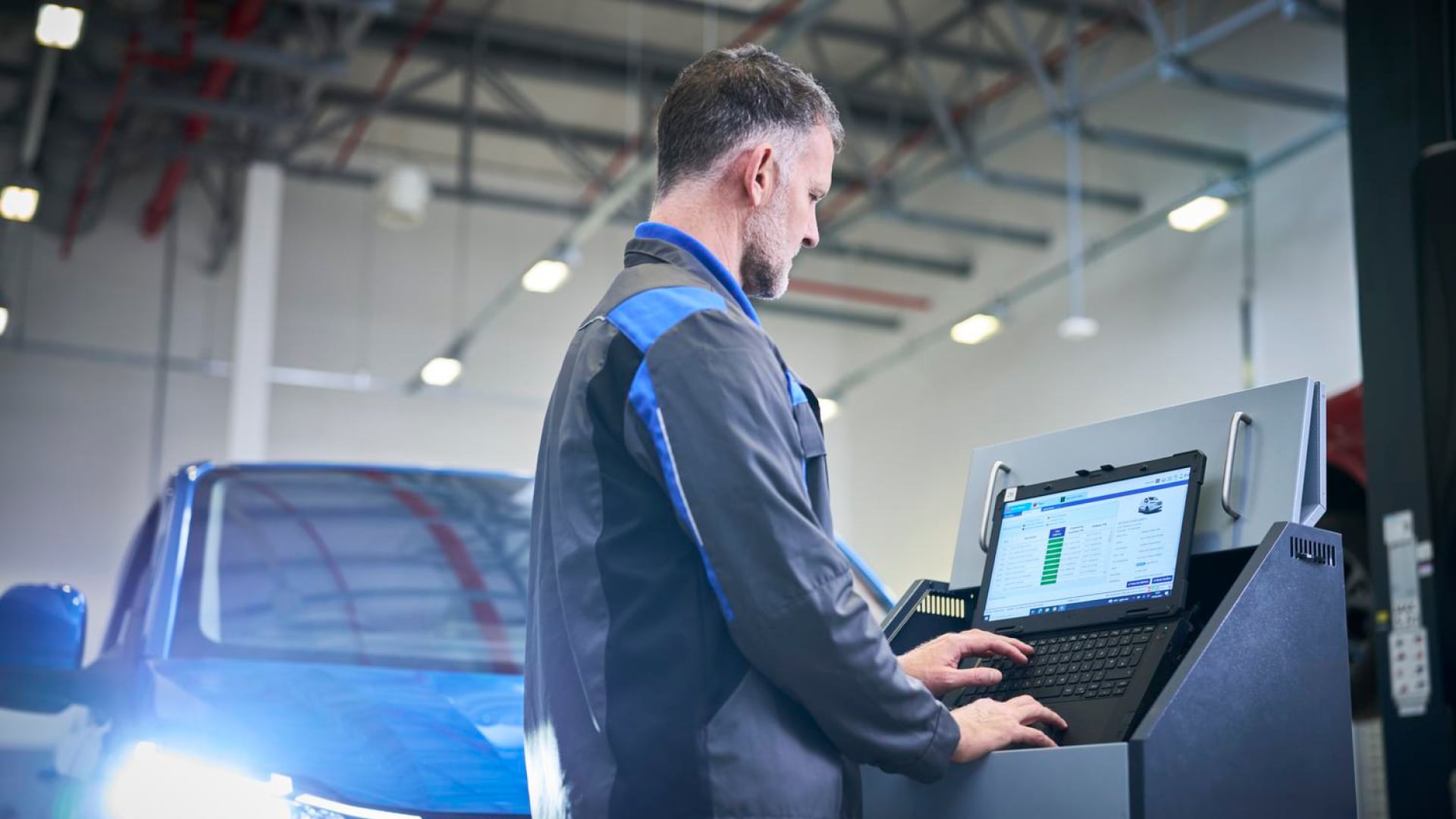 Kfz-Mechaniker bei der Arbeit mit einem Diagnoselaptop