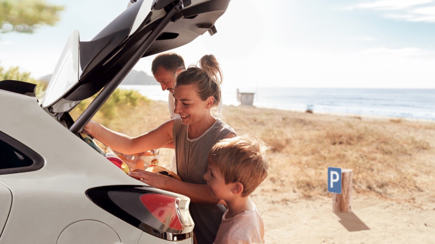 Eine Familie am Strand, die den Kofferraum ihres Ford belädt