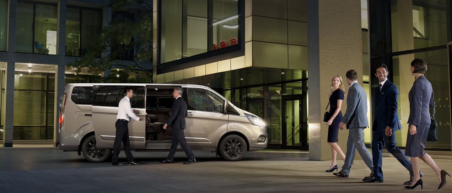 Ford Tourneo Custom in Silber. Seitenansicht mit geöffneter seitlichen Schiebetür