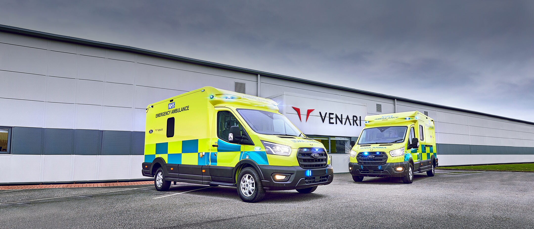 Zwei umgebaute Ford Ambulanzfahrzeuge auf einem Parkplatz