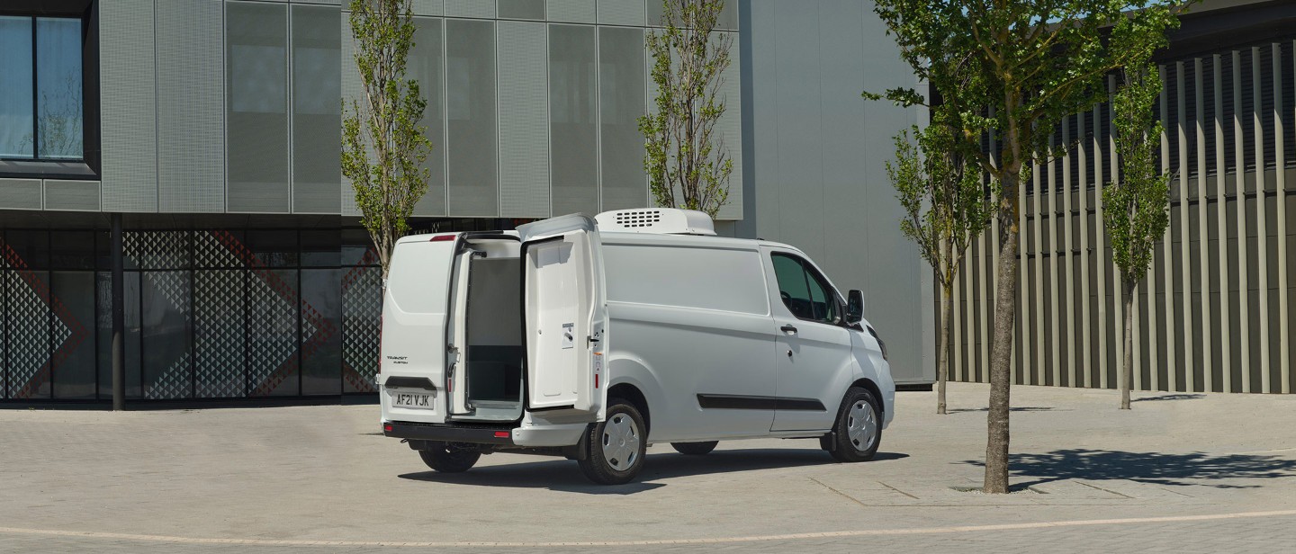 Ford Transit Custom Umbau in Weiß. Dreiviertelansicht, mit geöffneten Hecktüren